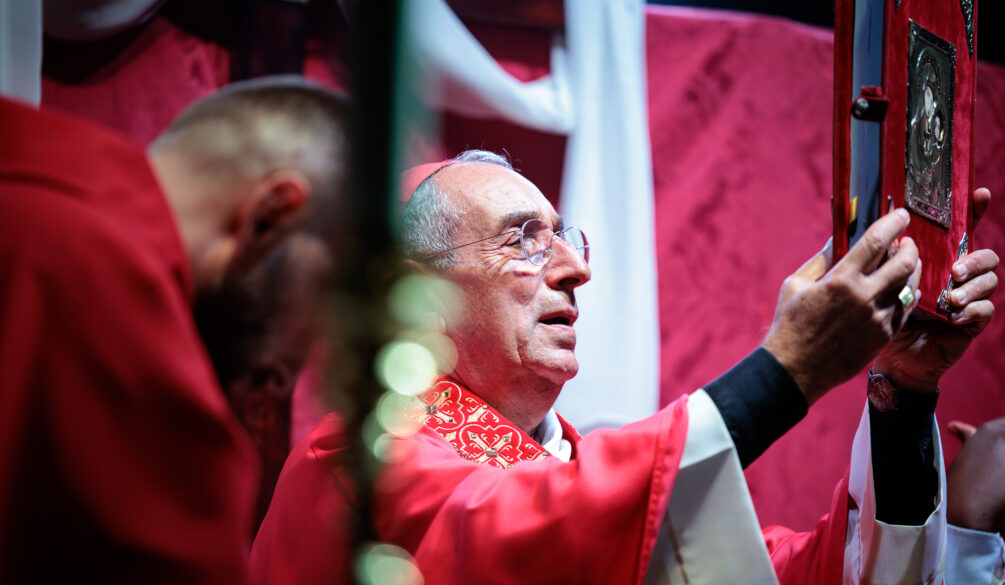 Il cardinale Angelo De Donatis solleva il libro liturgico durante la Messa per la festa patronale di San Romano Martire a Roma.