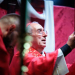 Il cardinale Angelo De Donatis solleva il libro liturgico durante la Messa per la festa patronale di San Romano Martire a Roma.