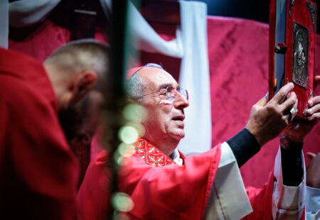 Il cardinale Angelo De Donatis solleva il libro liturgico durante la Messa per la festa patronale di San Romano Martire a Roma.